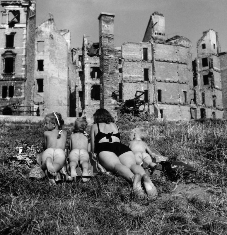 A mother and her children sunbathing among the ruins in post WW II Vienna. The children are doing a spot of nude sun worship. Original Publication: In black and white book  (Photo by Ernst Haas/Getty Images)