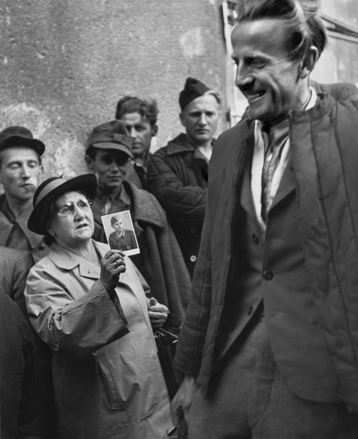 Premium Rates Apply. A smiling prisoner of war returning home to Vienna passes a woman holding a photograph up in a mixture of hope and despair. Original Publication: In black and white book  (Photo by Ernst Haas/Getty Images)
